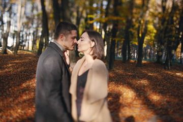 lovely couple walking around the park during autumn