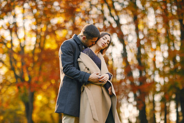 lovely couple walking around the park during autumn