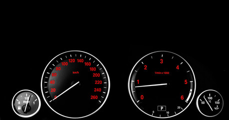 Fototapeta premium Detale deski rozdzielczej wnętrza samochodu z lampkami sygnalizacyjnymi. Detale samochodu. Tablica przyrządów samochodowych. Deska rozdzielcza zbliżenie z widocznym prędkościomierzem i poziomem paliwa. Licznik kilometrów, obrotomierz. Silnik wysokoprężny.