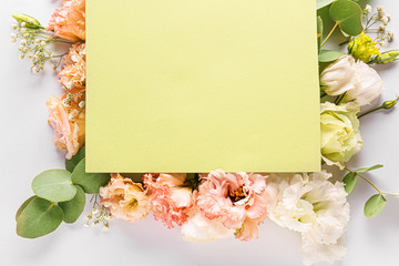 Beautiful composition with flowers and blank card on white background