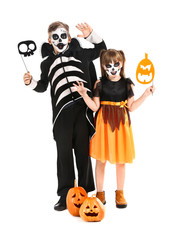 Little children in Halloween costumes on white background