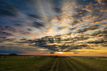 Obraz na płótnie Canvas panorama of blue red sky background with evening fluffy curly rolling clouds with setting sun. Good windy weather