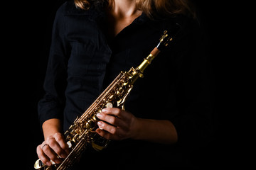 Fototapeta na wymiar soprano saxophone in hands on a black background