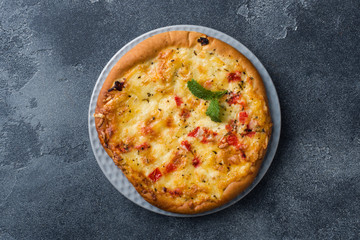 Homemade pizza tortilla with tomato and cheese on gray concrete background. Copy space