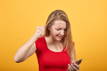 Fototapeta premium young blonde girl in red t-shirt over isolated orange background shows emotions