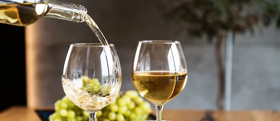 Rolgordijnen Waiter pouring white wine into wineglass.  © Aerial Mike