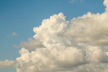 White powerfully cumulus clouds on a blue sky.