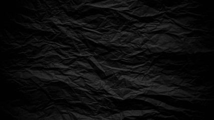 Dark black crumpled paper close up texture background