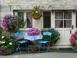 Fototapeta na wymiar une maison fleurie avec une table et des chaises