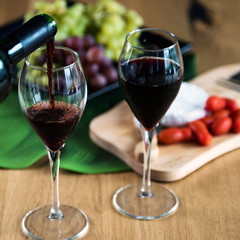 Waiter pouring red wine into wineglass. 