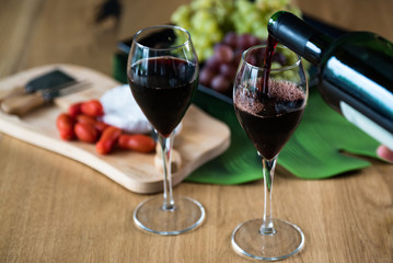 Waiter pouring red wine into wineglass. 
