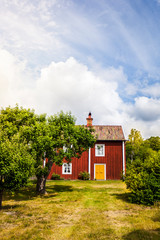 Schwedisches Haus mit roter Fassade in schönem Garten. Scandinavian house on countryside. Red old...