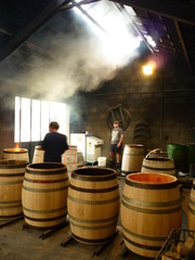 Des tonneliers fabricant des tonneaux. Une tonnellerie chauffant les barils. La fabrication de...