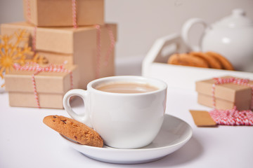 Cup of tea, homemade cookies, Christmas gift boxes and Christmas decor on the white background.
