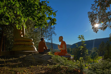 30-year-old man in a lotus position sits outdoors near the Buddha statue, in Quebec Harrington. Travel to Canada