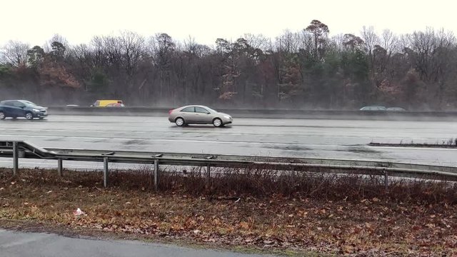Side-shot view of moderate traffic moving during rainy days at the A5 Highway, Frankfurt, Germany in slow motion