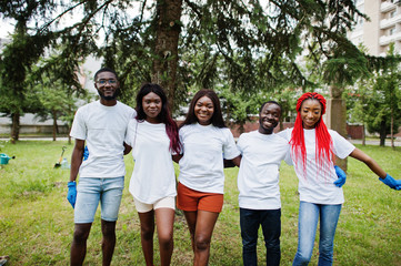 Group happy african volunteers hugs together in park. Africa volunteering, charity, people and...