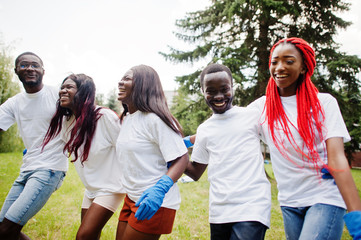 Group happy african volunteers hugs together in park. Africa volunteering, charity, people and...