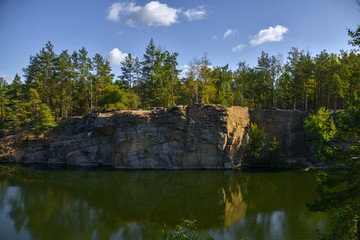 Fototapeta na wymiar Autumn lake on granite quarry with rocks