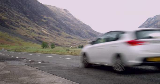 4K Road in the Scottish Glen Coe Mountain Highlands. Traffic travelling through a Mountainous Tourist Highway in Rural Scotland.