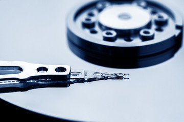 Closeup macro photo of head in opened hard disk drive. Concept of repair or recovery information...