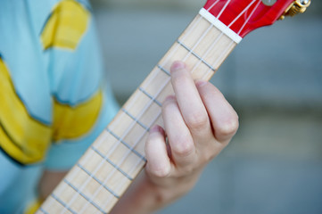 female hand clamps ukulele guitar strings