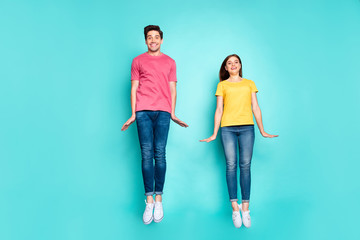 Fototapeta premium Full length body size view of nice attractive lovely cute funky cheerful cheery modest couple jumping in air having fun time isolated on bright vivid shine vibrant green turquoise background