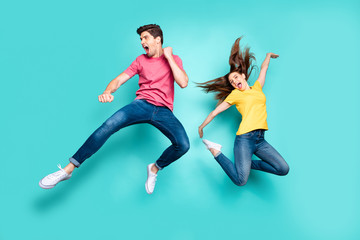 Fototapeta na wymiar Full length body size view of his he her she nice attractive crazy funky cheerful couple jumping in air having fun fooling rejoicing isolated on bright vivid shine vibrant green turquoise background
