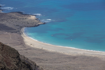 Fototapeta na wymiar beautiful empty beach with turquoise waters in volcanic island, Lanzaorte, Canary Island, Spain