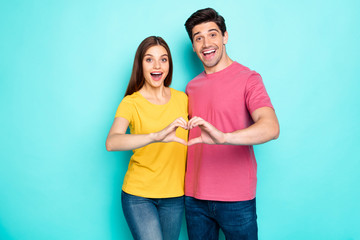 Portrait of his he her she nice attractive lovely charming positive excited cheerful cheery couple hugging showing heart symbol isolated over bright vivid shine vibrant green turquoise background