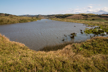  River Surrounded by Grassy Banks and Hills