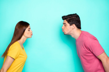 Profile side view portrait of his he her she nice attractive dreamy affectionate couple leaning kissing isolated over bright vivid shine vibrant green turquoise background