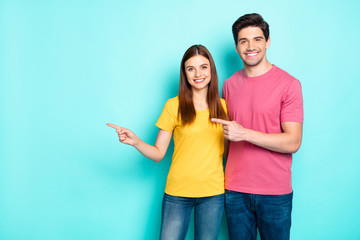 Portrait of his he her she nice attractive lovely cheerful cheery content couple hugging pointing aside ad advert solution isolated over bright vivid shine vibrant green turquoise background