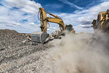 Excavator moving gravel in a quarry - obrazy, fototapety, plakaty
