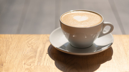 a cup of coffee stands on a wooden table. 