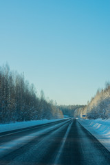 Vertical shot of winter road landscape on frosty sunny day.