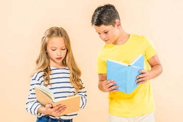 two kids in casual clothes reading books isolated on pink