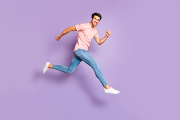 Fototapeta na wymiar Full body photo of amazing guy jumping high running to shopping center wear casual outfit isolated on purple color background