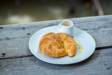 Croissants topped with honey on a white plate