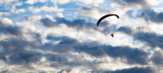 silhouette of skydiver with parachute - live your dream, freedom and adrenaline concept