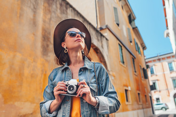 Attractive photographer with a retro camera outdoors