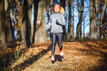 Young woman running training in autumn park