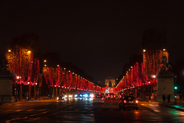 Fototapeta na wymiar Arch of Triumph and Champs Elysees with Christmas red festive illumination. Paris during winter holidays concept. Travel destination background. City nightlife banner.