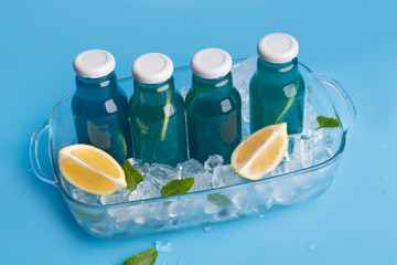 Close up of blue detox water in glass bottle with lemon slices