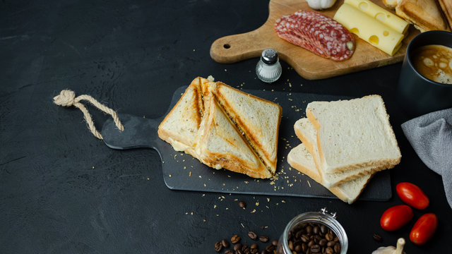 Domowe tosty z serem i salami. Ciemne tło, widok z g&oacute;ry.