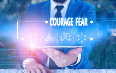 Fototapeta na wymiar Writing note showing Courage Fear. Business concept for quality of mind that enables a demonstrating to face difficulty Male wear formal work suit presenting presentation smart device