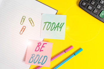 Text sign showing Be Bold. Business photo showcasing Go for it Fix it yourself instead of just talking Tough Hard Empty blue paper with copy space paper clips and pencils on the yellow table