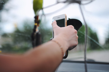 Girl touches the screen of a smartphone car navigator