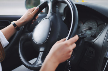 Naklejka premium Girl holding a car steering wheel