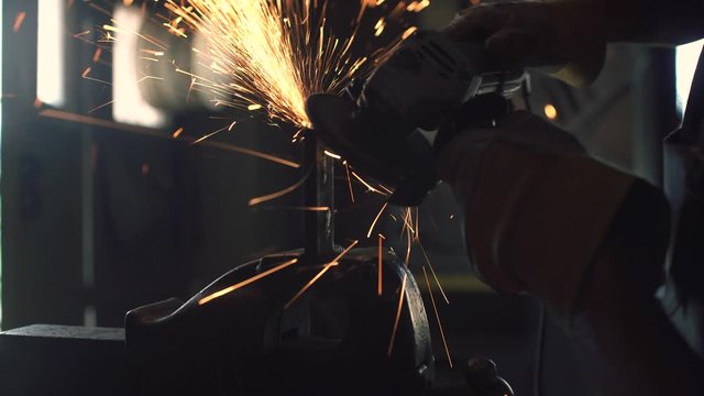 Professional blacksmith using an angle grinder